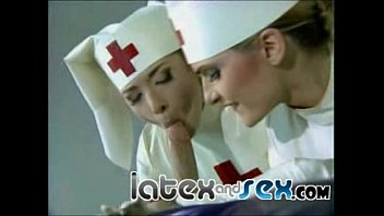 Latex-Krankenschwestern behandeln einen Kerl mit einer Gummimaske