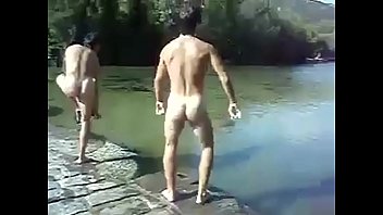 nackte Kerle springen in einen Fluss