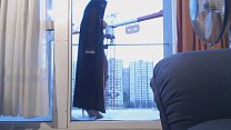 veiled muslim dancing on the balcony in front of a crane operator