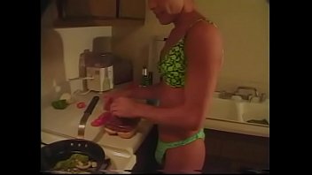 Gay bronzé en lingerie prépare le dîner dans la cuisine pendant que son ami le baise dans le cul