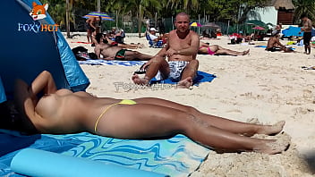 Prendre un bain de soleil seins nus sur la plage pour être regardé par d'autres hommes